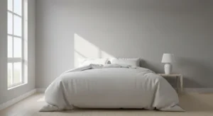 Light grey walls with white bedding creating a clean modern bedroom