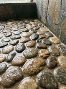 Textured pebble tile shower flooring for a natural and slip resistant design