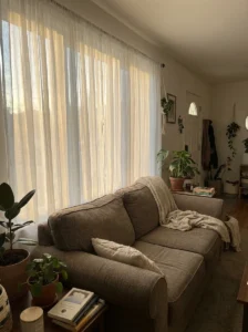 Brown couch with light curtains creating a soft and airy living room