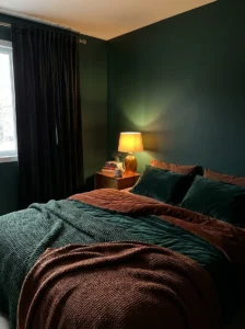 moody green bedroom with cozy dark tones and warm lighting
