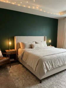 dark green accent wall bedroom with neutral decor and warm lighting