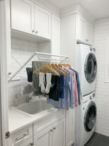 Fold-down drying rack mounted on wall in small laundry room space