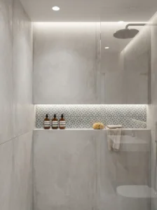 Shower niche storage built into wall with decorative tile detail