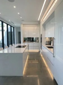 Glossy white kitchen cabinets reflecting light in a modern sleek kitchen