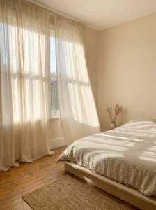 Neutral bedroom with soft flowing curtains and natural light