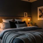 Dark bedroom with warm lighting and cozy textures creating a moody and inviting space