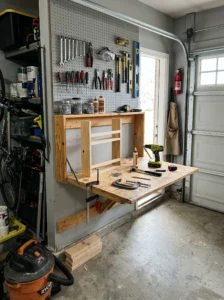 Wall-mounted folding workbench inside a compact organized garage.
