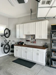 Old kitchen cabinets reused for hidden garage storage organization.