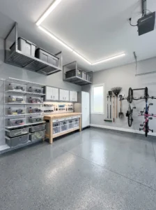 Organized modern garage featuring wall storage, shelving, overhead racks, and a clean workspace.