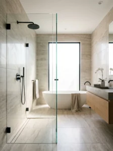Frameless glass walk-in shower with modern fixtures and minimalist bathroom design.
