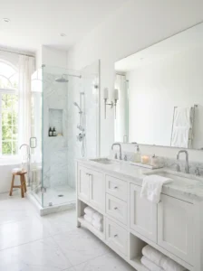 Bright white bathroom with marble surfaces and modern minimalist design.