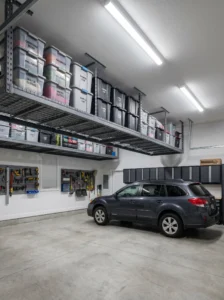 Garage overhead storage racks holding labeled storage bins above parked vehicles.