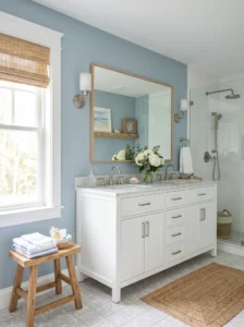 Dusty blue bathroom with coastal-inspired decor and white vanity.