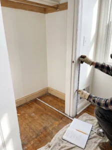 Measuring a spare closet before converting it into a pantry