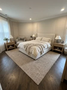 Master bedroom with a diagonal herringbone rug anchoring an awkward furniture layout