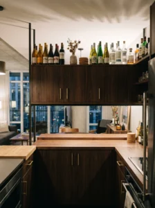 Wine and liquor bottles styled above cabinets in a modern kitchen