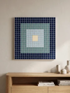 Geometric square mosaic plaque with concentric navy, teal, pale-blue, and ivory tile rings.