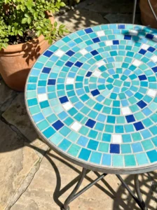 Colorful square mosaic tabletop with a balanced confetti scatter of aqua, turquoise, blue, navy, and white tiles.