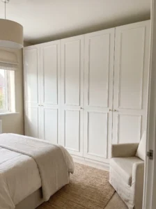 IKEA PAX wardrobe doors upgraded with evenly spaced applied molding for a classic white Shaker-style built-in look.