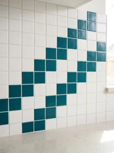 Deep teal square tiles forming a stepped zigzag pattern against white mosaic tiles on a kitchen accent panel.