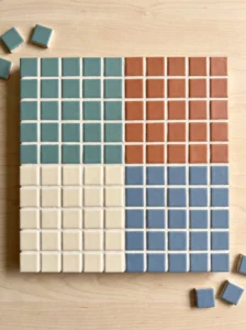 Square mosaic trivet divided into four equal color-blocked quadrants of teal, terracotta, ivory, and dusty blue tiles.