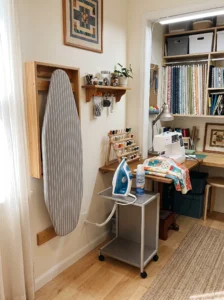 Corner ironing station with a wall-mounted folding ironing board in a sewing room