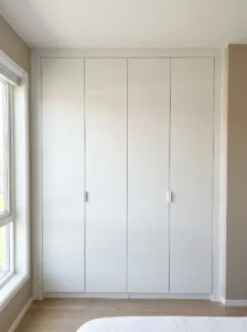 Wall-to-wall IKEA PAX wardrobe with matching filler panels that eliminate side gaps for a custom fitted finish.